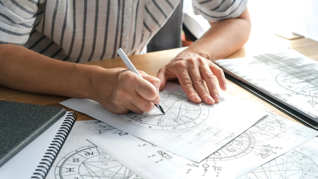 Persona haciendo cálculos astrológicos - Astronumerología - Voces Holísticas